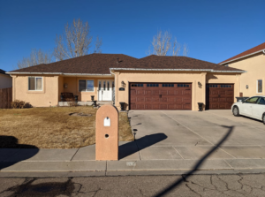 Two brown carriage-style garage doors installed on a home by Southern Colorado Garage Door in Pueblo, CO.
