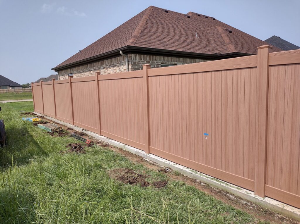 A sturdy brown composite privacy fence installed in a residential backyard by Pro Insulation and Fence in Wichita Falls, TX.