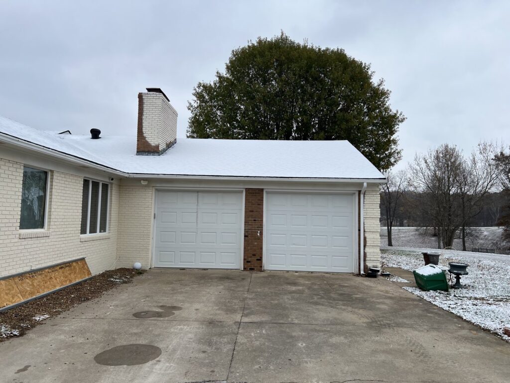 A brown garage door installed on a residential home by Precision Garage Door of Owensboro Evansville in Owensboro, KY.