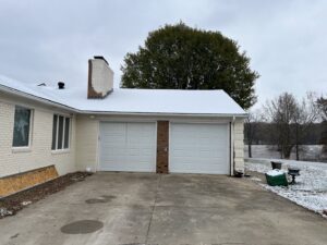 A brown garage door installed on a residential home by Precision Garage Door of Owensboro Evansville in Owensboro, KY.