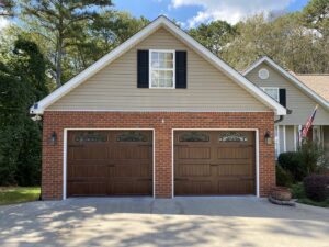 Two brown garage doors with decorative windows and hardware installed by Access Garage Doors-Chattanooga, TN