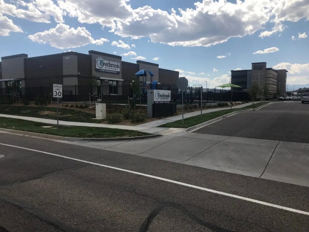 A modern brown horizontal slat privacy fence enclosing a patio area next to a residential home, installed by Best Boy's Fencing in Fort Collins, CO.