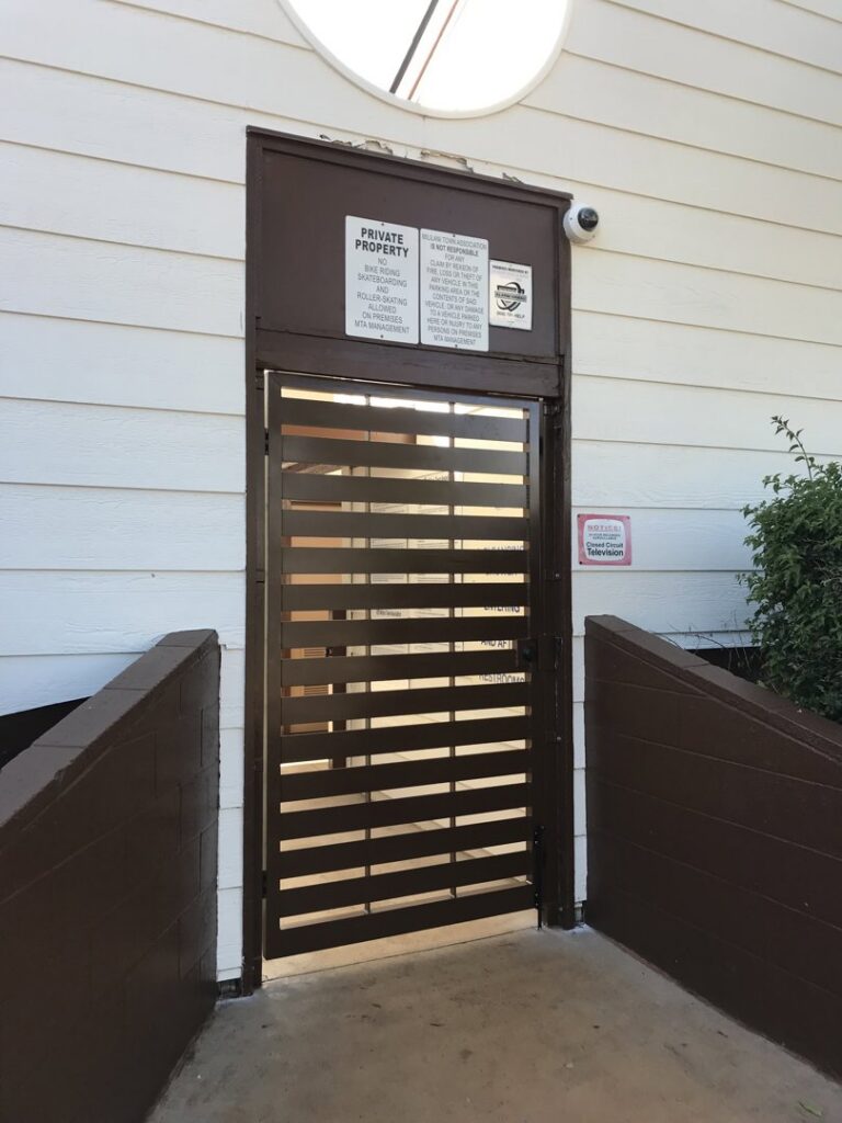 A brown horizontal slat security gate with private property signs installed by A&D Services in Kapolei, HI.