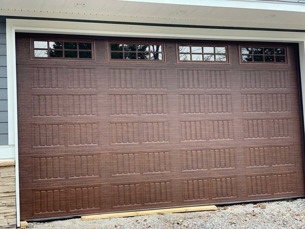 A stylish brown panel garage door with decorative windows installed by Rose Quality Garage Doors in Murfreesboro, TN