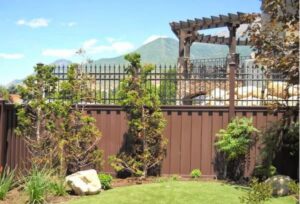 A brown privacy fence with an ornamental top section, installed by Stonehenge Fence & Deck in Orem, UT.