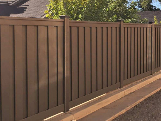 A sturdy brown privacy fence installed along a sidewalk by Superior Fence & Rail of North Shore in Gulfport, MS.