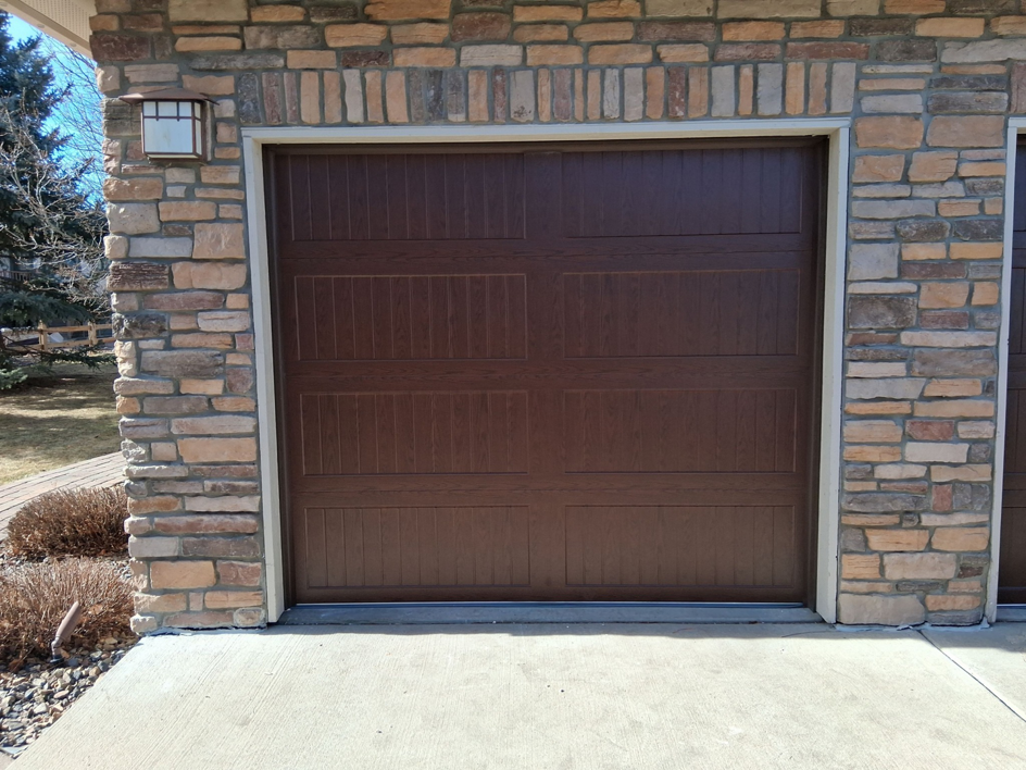 A newly installed brown residential garage door by Usa Garage Door Services and Construction, LLC at 1206 E 6th St, USA.