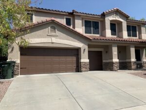 A residential home featuring two brown garage doors installed by Fix It Now Garage Doors.com in Tempe, AZ.