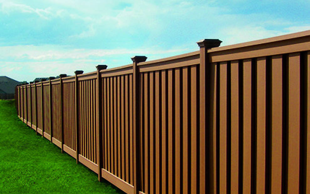 Attractive brown vinyl privacy fence installed along a property line by Wildfire Products Inc. in West Fargo, ND
