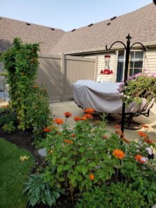 A modern brown vinyl privacy fence creating a secluded patio area by Top Notch Fence in East Bethel, MN