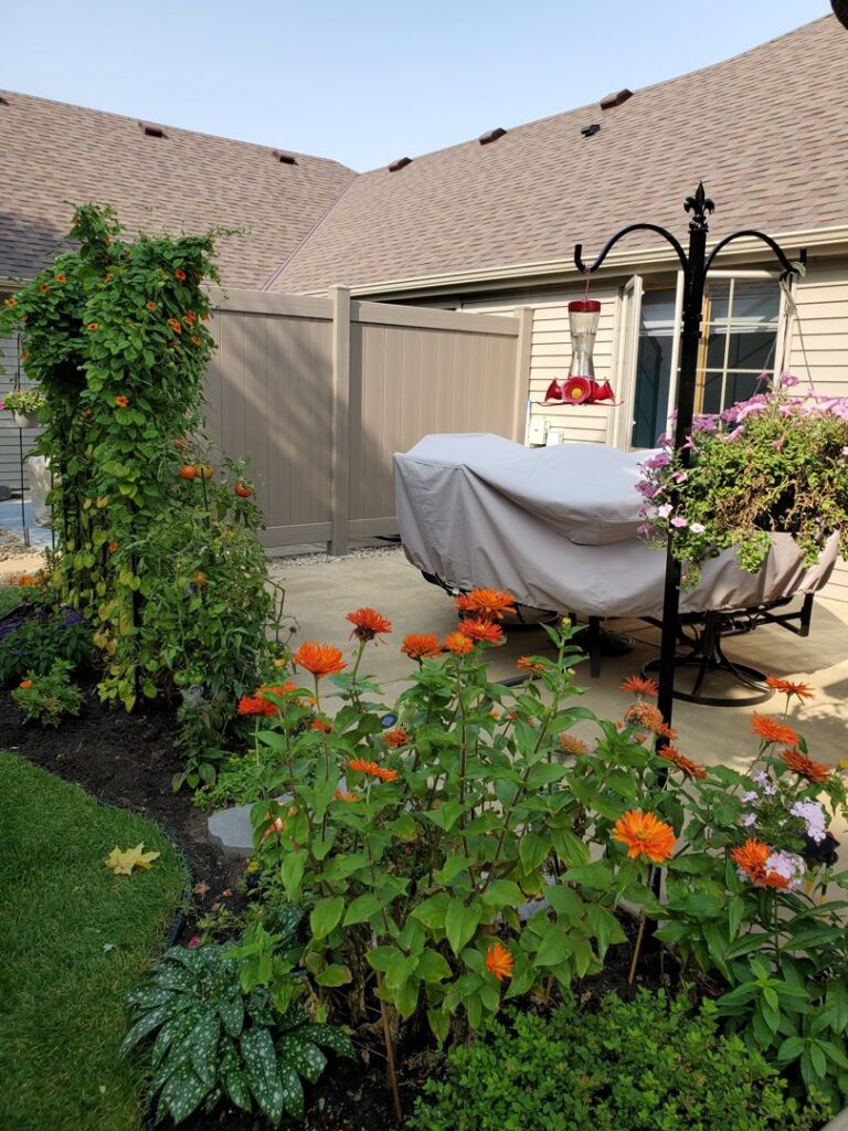 A modern brown vinyl privacy fence creating a secluded patio area by Top Notch Fence in East Bethel, MN