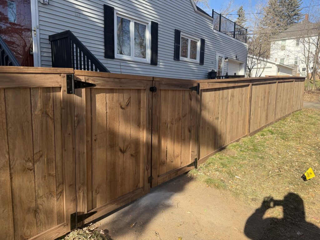 A brown wooden privacy fence with a matching gate installed by North Shore Fence Company in Centereach, NY.
