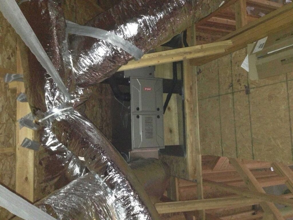 A Bryant furnace and air handler unit installed in an attic with ductwork by Rhino Heating and Air Conditioning LLC in Norman, OK.