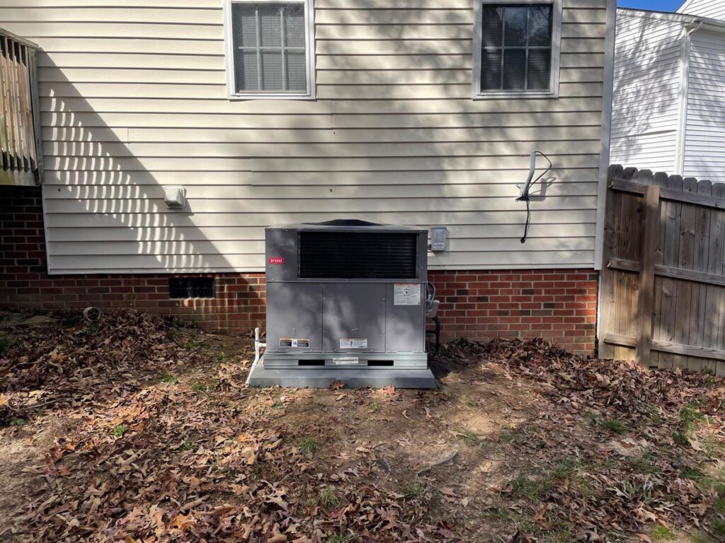 A Bryant outdoor HVAC unit newly installed next to a residential home by Luciano's Air Services in Durham, NC.