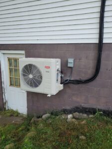 A Bryant mini-split outdoor unit installed on a brick wall by T. D'Albora Heating and Cooling in Erie, PA.