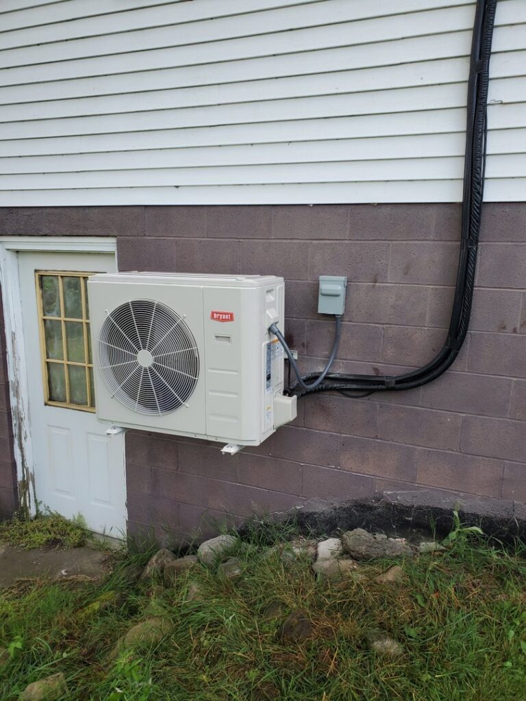 A Bryant mini-split outdoor unit installed on a brick wall by T. D'Albora Heating and Cooling in Erie, PA.
