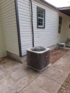 An outdoor Bryant air conditioning unit installed next to a residential house by The Right Flow Heating and Air LLC in Lawton, OK