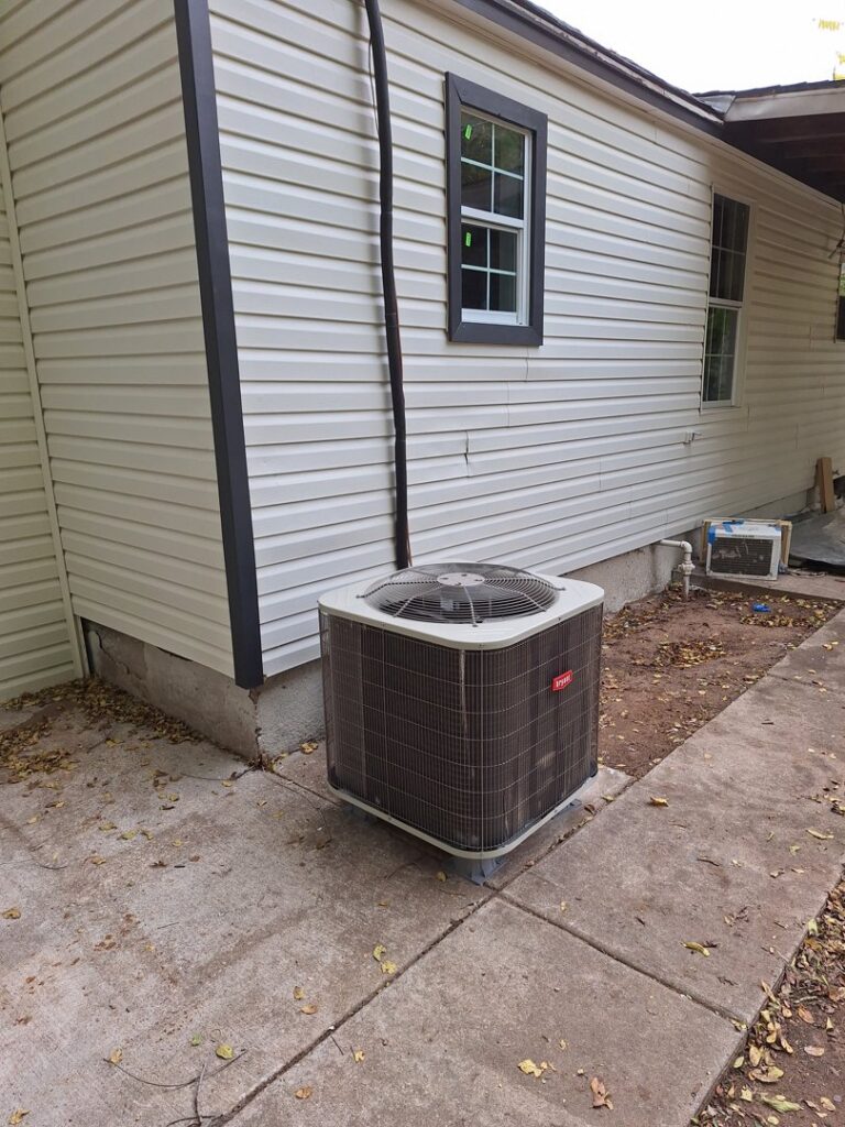 An outdoor Bryant air conditioning unit installed next to a residential house by The Right Flow Heating and Air LLC in Lawton, OK
