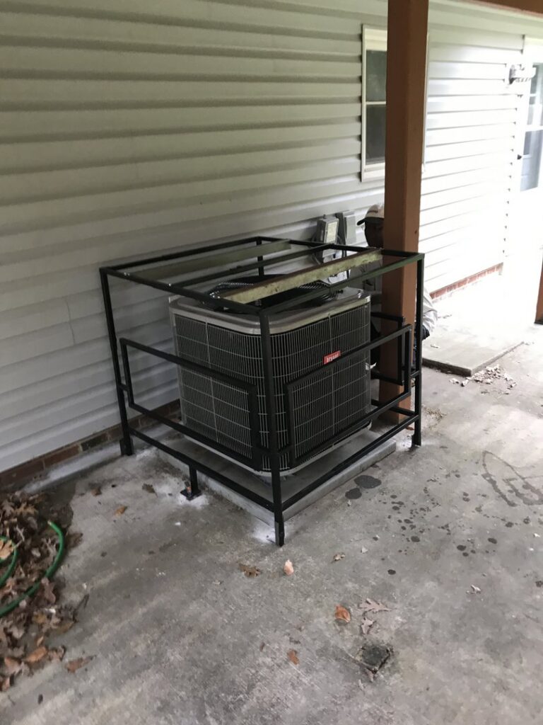 A Bryant outdoor AC unit enclosed in a protective metal cage, installed by JDL HVAC Services, LLC in Laurel, MD.