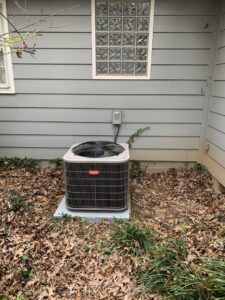 A Bryant outdoor HVAC condenser unit installed beside a residential building by Systematic Heating & Air in Winston-Salem, NC.