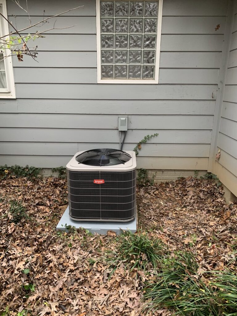 A Bryant outdoor HVAC condenser unit installed beside a residential building by Systematic Heating & Air in Winston-Salem, NC.