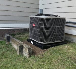 A newly installed Bryant outdoor HVAC unit next to a residential building by Kelley Brothers LC in Livonia, MI.