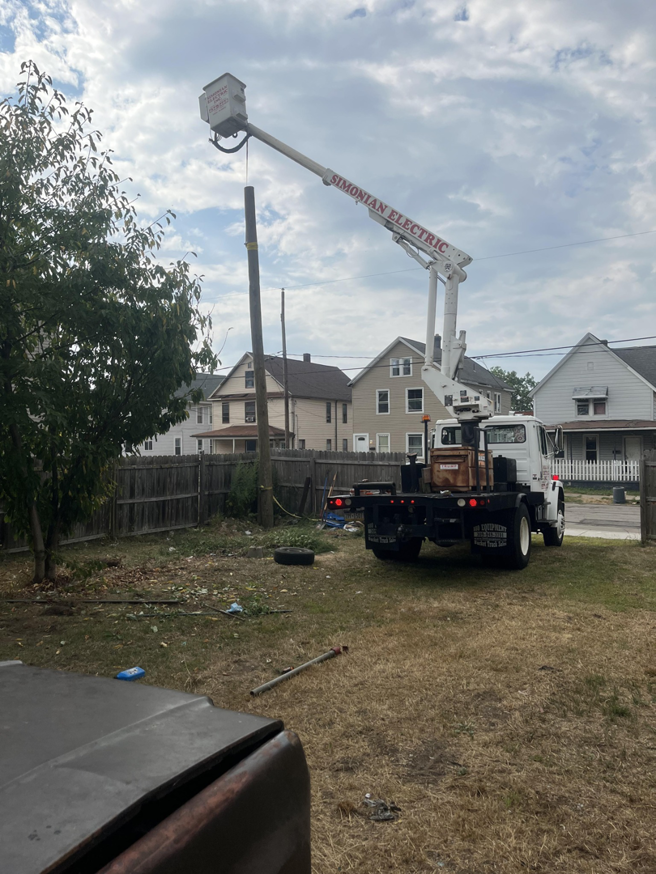 A bucket truck performing utility pole repair work in a residential area by DRS Electric Co. in Erie, PA.