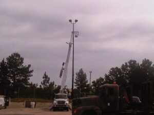 A bucket truck with its boom extended, working on a parking lot light pole for Argosy Electric, Inc. in Newport News, VA
