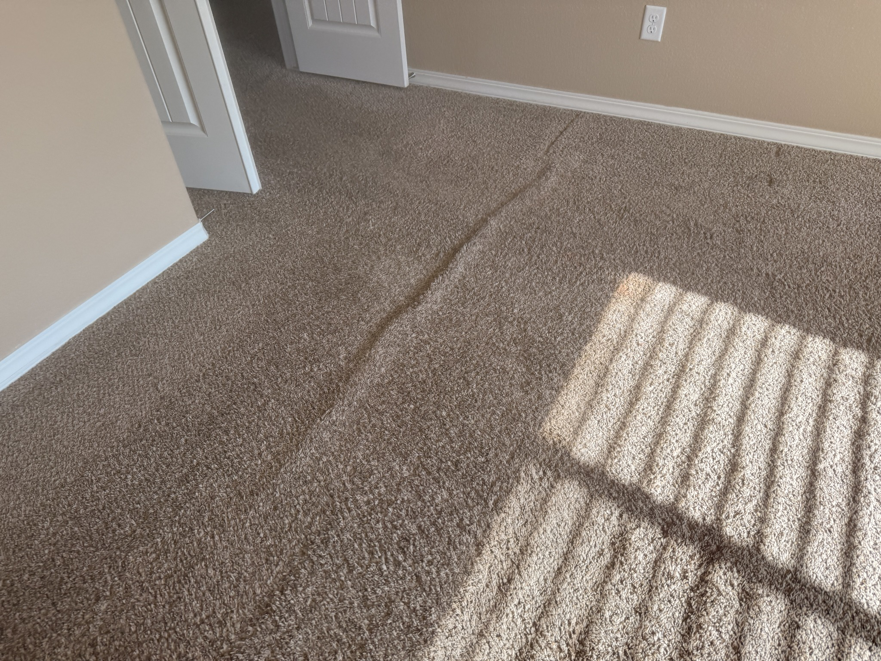 A buckled carpet needing repair or stretching, a service offered by Believe That Carpets & Upholstery Cleaning in Colorado Springs, CO.
