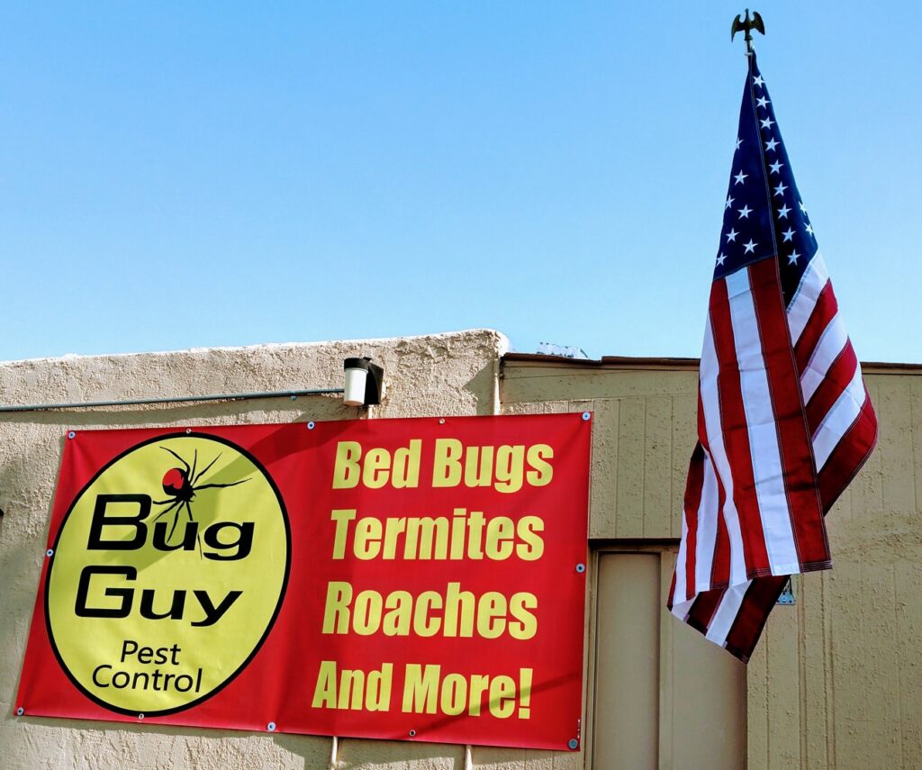 The exterior of Bug Guy Pest Control building during the day, advertising bed bug, termite, and roach services in Las Cruces, NM.