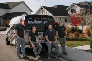 The Bullseye Carpet & Upholstery Cleaning team posing with their branded service van in a residential neighborhood in Boise, ID.