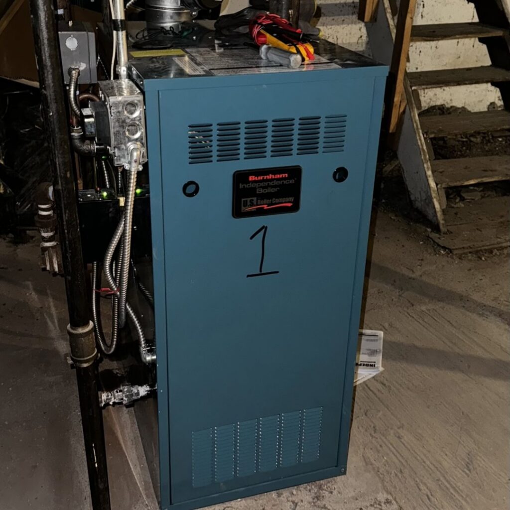 A Burnham Independence boiler unit installed in a basement by PureTemp Heating and Cooling in Salem, NH.