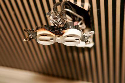 A close-up of a burnt electrical outlet needing repair, a service provided by M/C Electric in Lexington, SC.