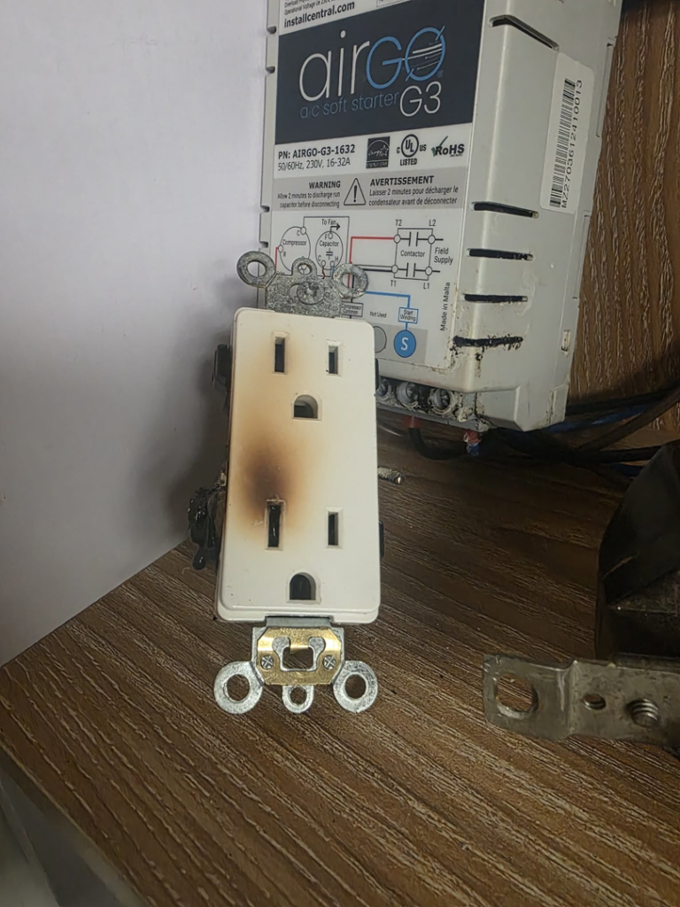 A burnt electrical outlet next to a control box, showing an electrical repair need by Mr. Electric of Rogers in Rogers, AR.