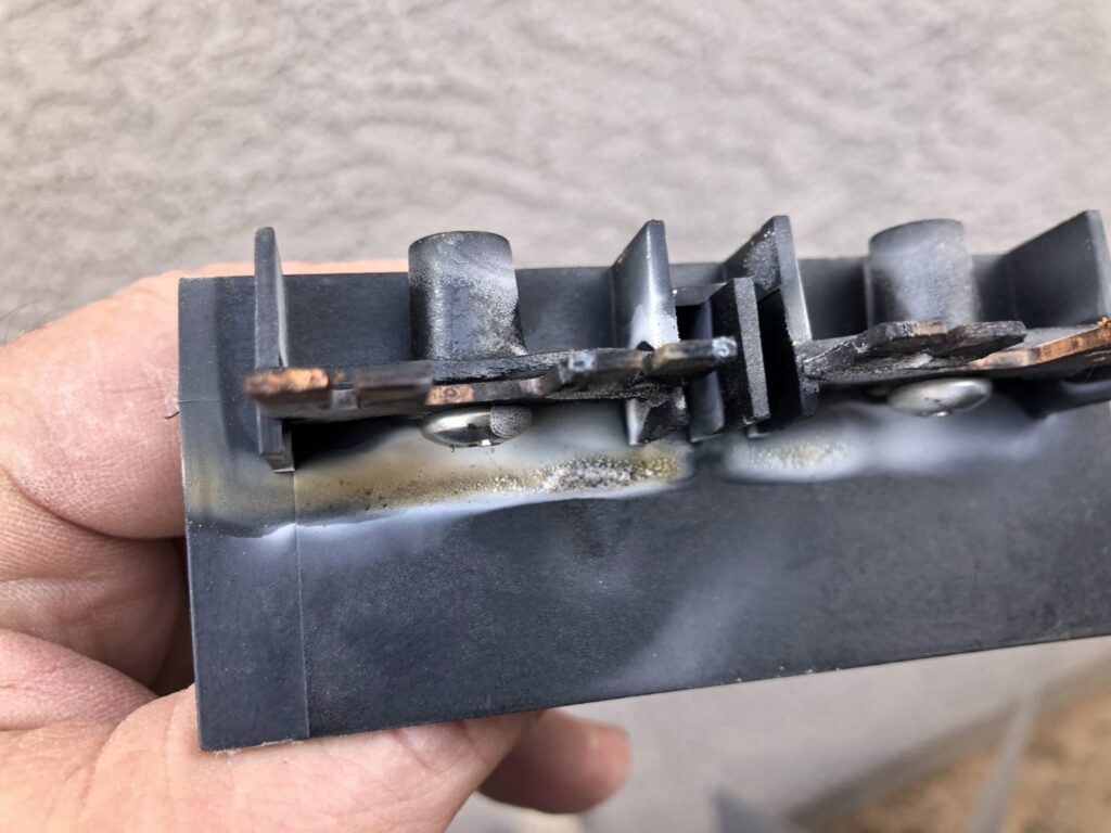 A close-up of a burnt electrical component from an HVAC system, indicating a repair needed by All Metro Air Conditioning in Apache Junction, AZ.