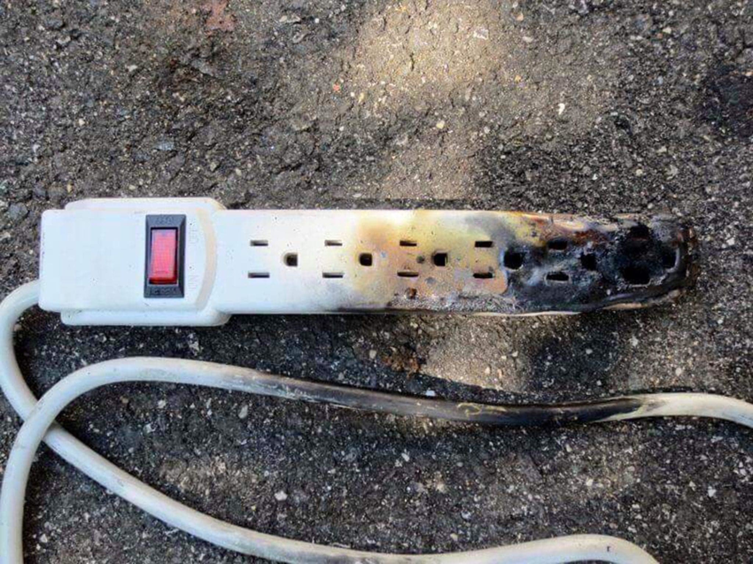 A severely burnt and damaged power strip, indicating an electrical hazard, addressed by FRK_Electrical_Contractors in Chicago, IL