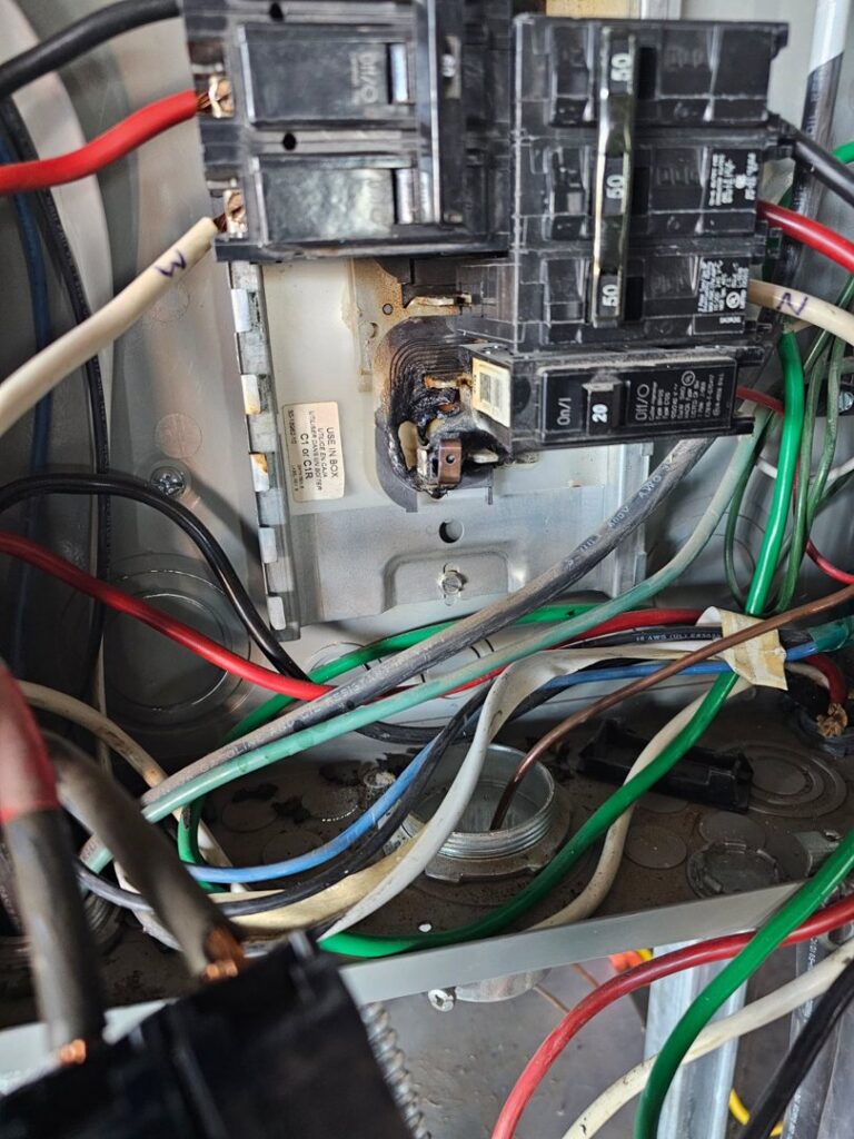 Close-up of an electrical panel with burnt wiring and damaged circuit breakers by Elite Electric Company in Melrose Park, IL