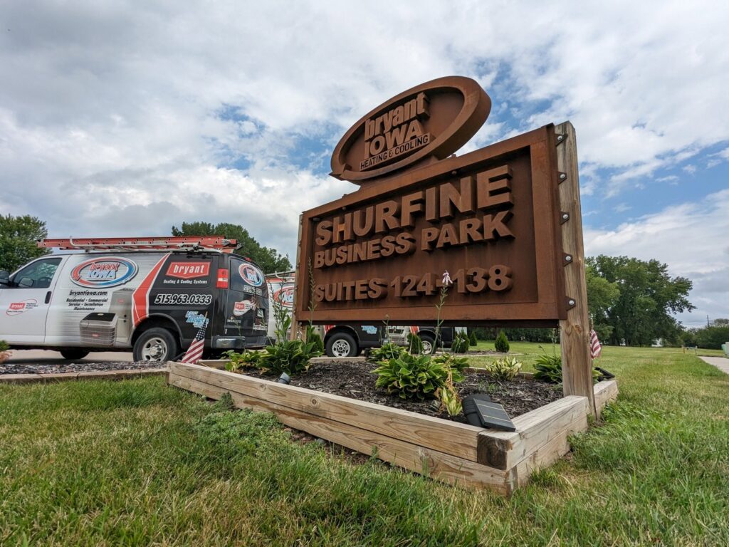 The Shurfine Business Park sign with a Marie Keding Bryant Iowa Heating and Cooling service van in the background in Ankeny, IA.