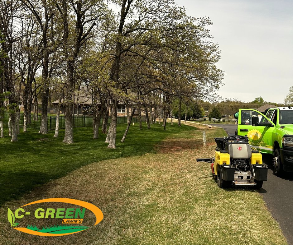 A C-Green Lawns truck and a walk-behind spreader machine parked on a residential lawn in Yukon, OK.