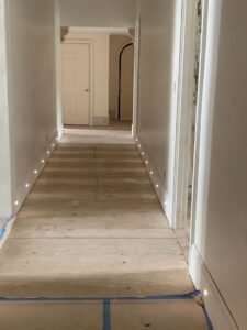 A cabinet with interior lighting showcasing bottles, installed by Johnson Electric in Port Angeles, WA.