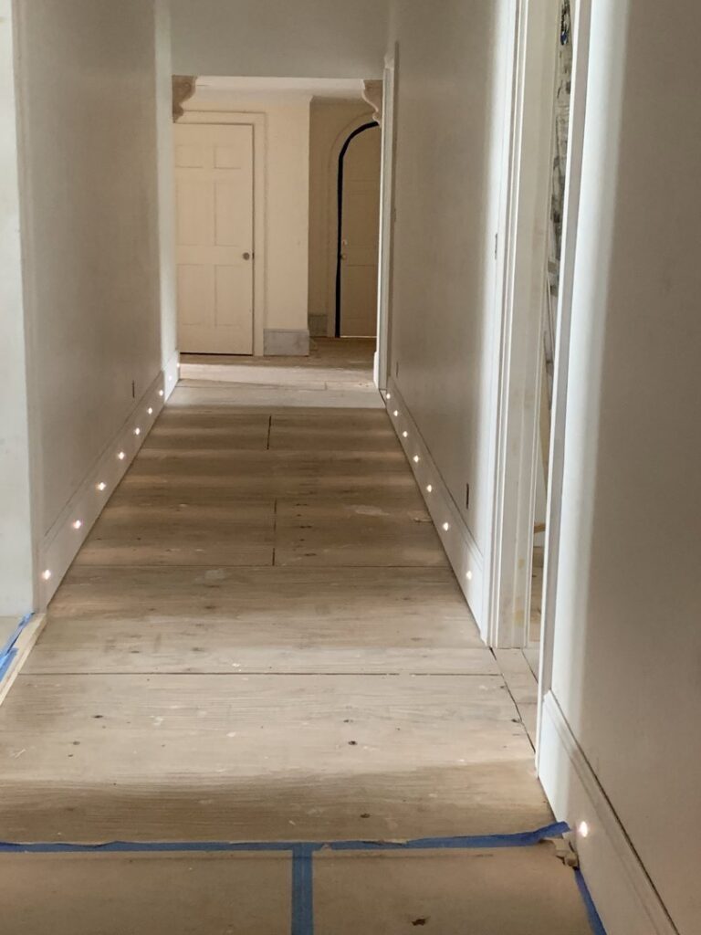 A cabinet with interior lighting showcasing bottles, installed by Johnson Electric in Port Angeles, WA.