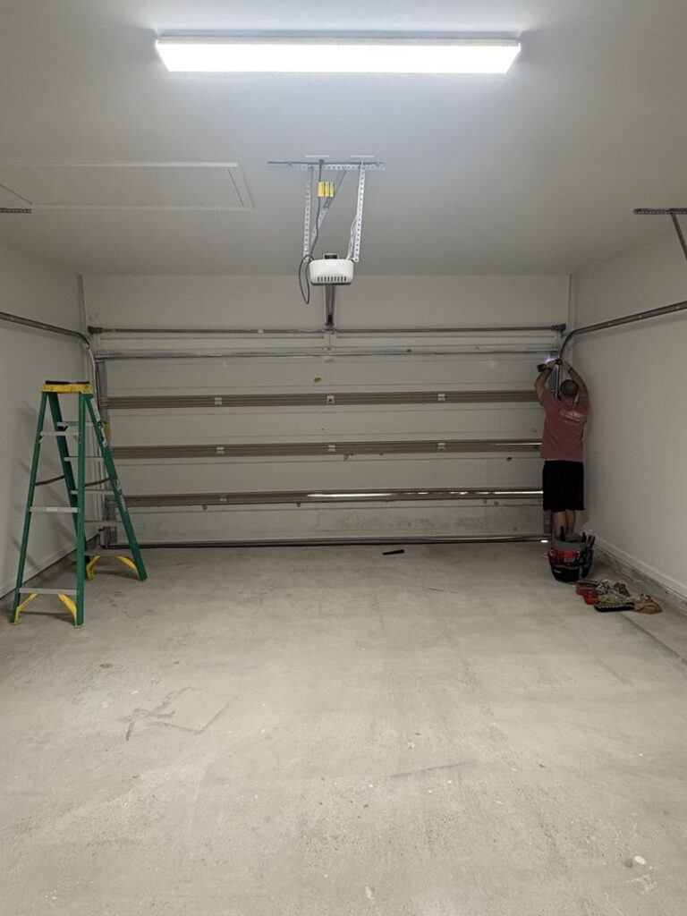 A worker from Cajun Doors & More in Lafayette, LA, wearing a company shirt and working on a wooden door panel outdoors.