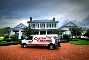The Captain Steamer service van parked in front of a large residential home in Cape Coral, FL.