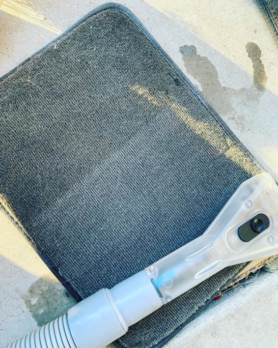 A carpet cleaning tool actively cleaning a dirty car floor mat by Humble Carpet Cleaners in Mesa, AZ