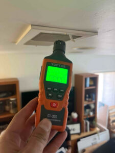 A technician performing a carbon monoxide detection safety check near an HVAC vent for Number 1 Plumber in Washington, DC.
