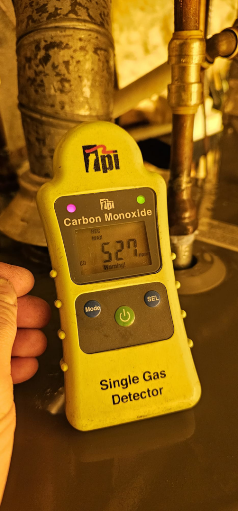 A carbon monoxide detector showing a warning, indicating HVAC safety inspection by Glacier Air Conditioning & Refrigeration Ltd. in Chilliwack, BC.