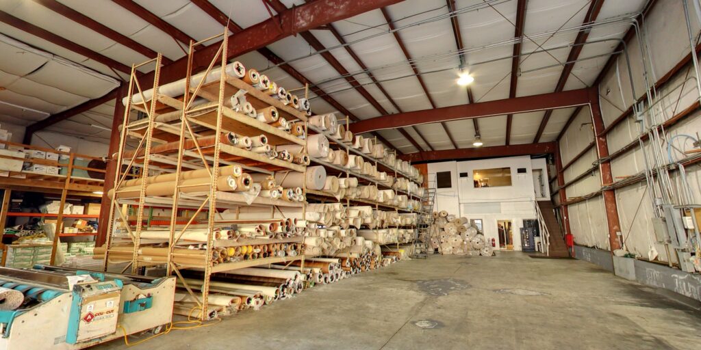 Large rolls of carpet and flooring materials stored in the warehouse of Get Steamed Carpet Cleaning, Inc. in North Charleston, SC.