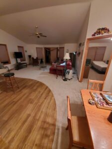 A living area featuring a seamless transition between new carpet and hardwood flooring by Integrated Flooring in Burton, MI.