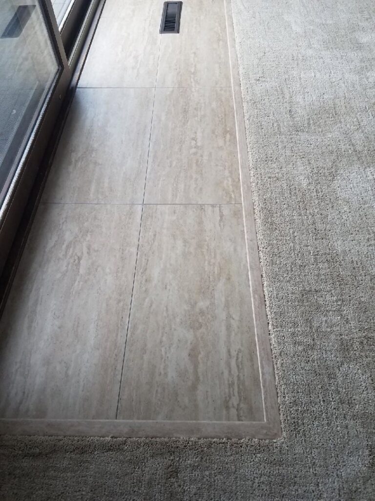 A clean transition between light-colored carpet and tile flooring installed by Great Spaces Floor Co in Minneapolis, MN.