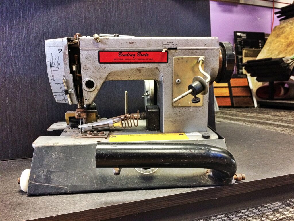 A 'Binding Brute' carpet binding machine used for custom rug finishing at Carpet Maven Flooring in Woodbridge, NJ.